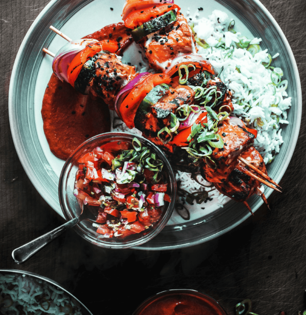 Grilled skewers with marinated meat and vegetables, served with white rice, fresh salsa, and red dipping sauce, perfect for the dinner category.