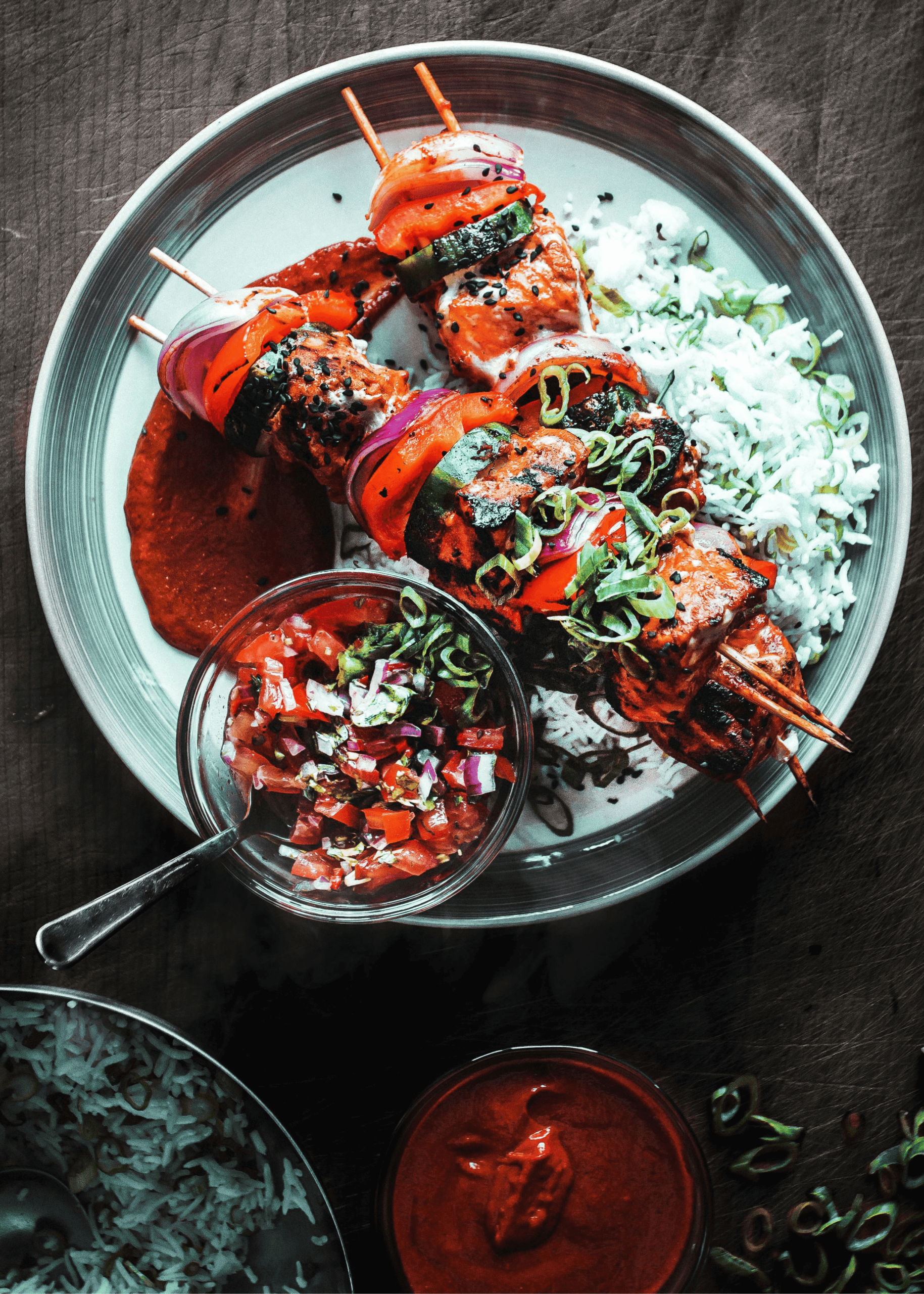 Grilled skewers with marinated meat and vegetables, served with white rice, fresh salsa, and red dipping sauce, perfect for the dinner category.